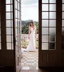 Capturando a essência da Luuly Noivas, esta noiva exala graciosidade em um vestido de noiva sereia clássico. Com detalhes delicados em renda e um corte que realça a silhueta, o vestido é a escolha perfeita para um casamento deslumbrante. A pose serena da noiva e o elegante cenário aberto proporcionam uma visão encantadora de um traje feito para momentos inesquecíveis.