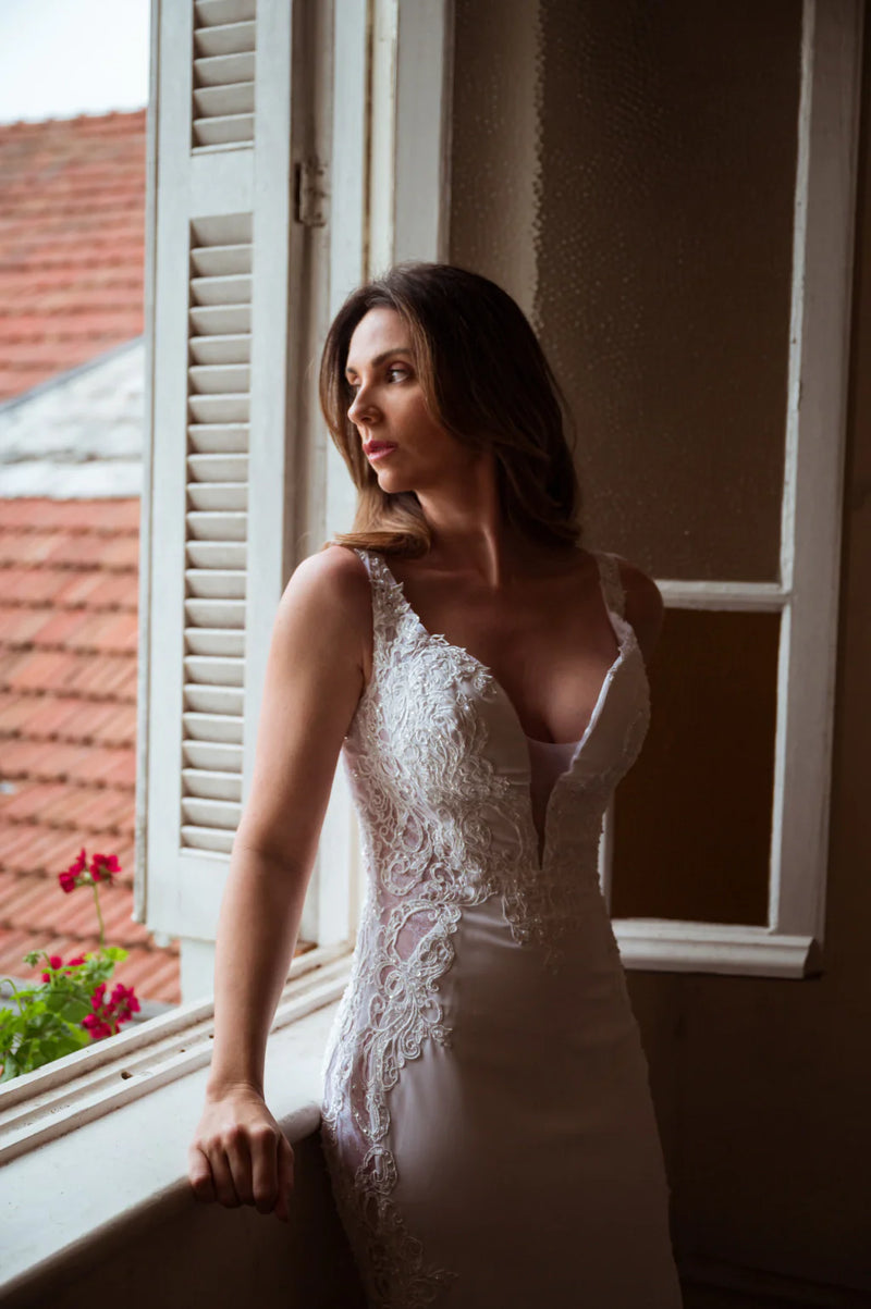 Vestido de noiva elegante estilo sereia com detalhes em renda, projetado para realçar a beleza natural da noiva brasileira. O vestido combina classe e sofisticação, ideal para destacar-se em um casamento contemporâneo.